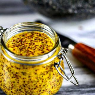 A jar of homemade stone ground mustard sitting on top of a table