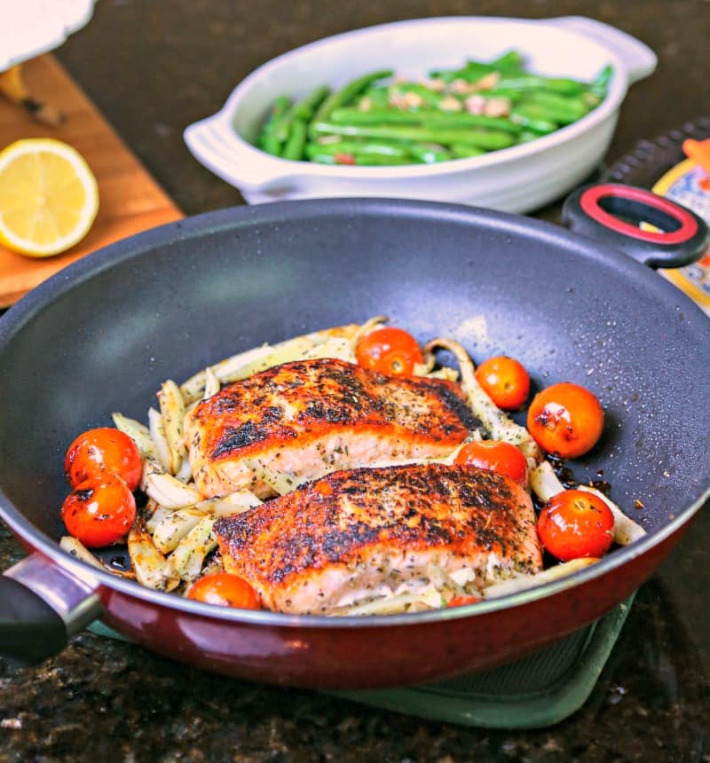 A skillet of Mediterranean Salmon on top of fennel and tomatoes