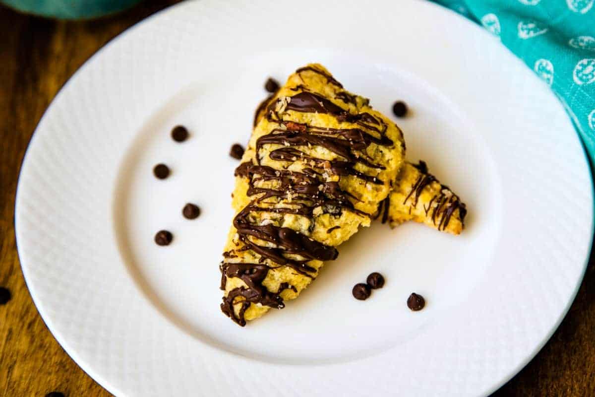 Mini Chocolate Chip Scones on a white plate with chocolate chips scattered around