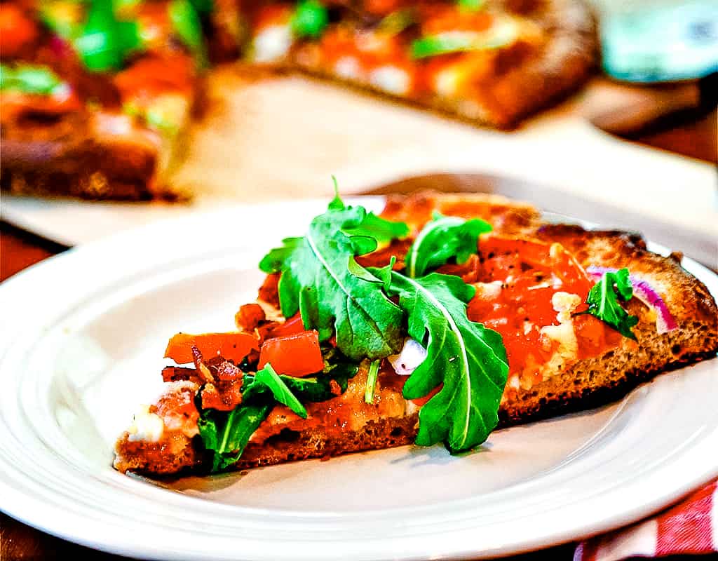 Slice of BLT pizza on a white plate