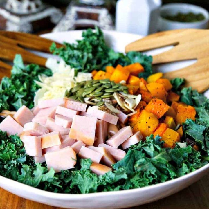 A bowl of autumn salad with butternut squash, turkey, and kale