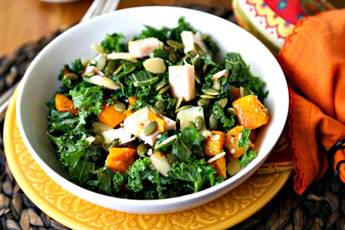 A bowl of autumn salad with butternut squash, turkey, and kale