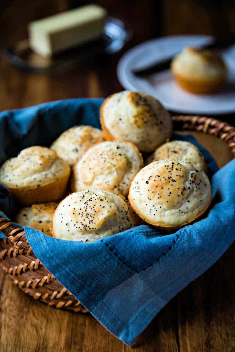 a bread basket lined with a blue napkin filled with 3-ingredient dinner rolls