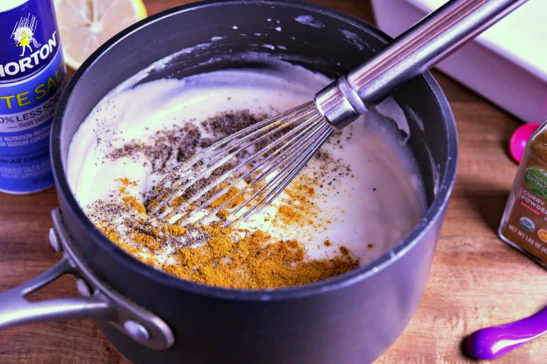 a saucepan and whisk, with cream and spices