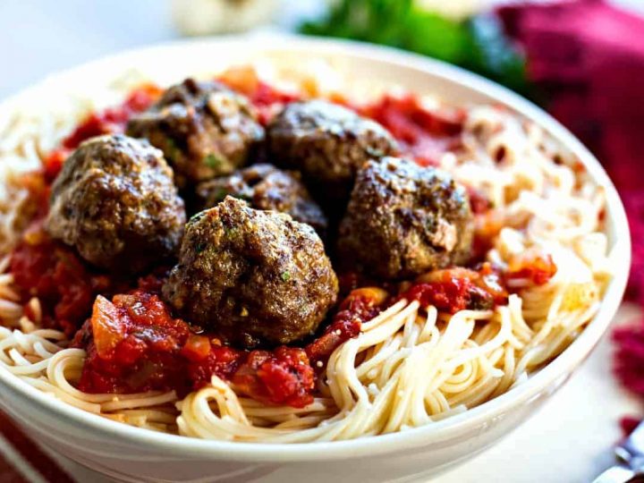 A dish is filled with food, with spaghetti and meatballs