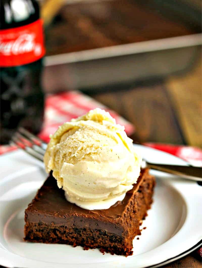 A piece of chocolate cake on a plate topped with ice cream