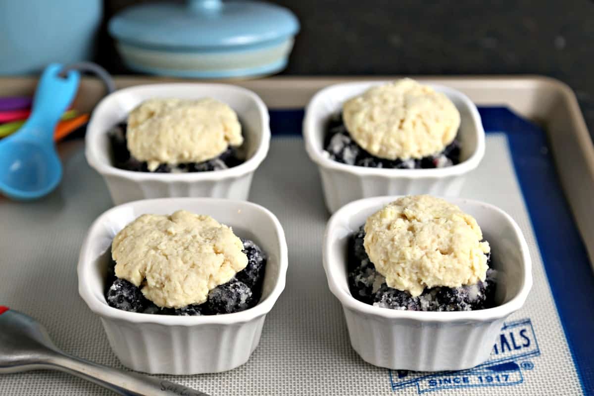 Ramekins on a baking sheet, with Blackberry Cobbler