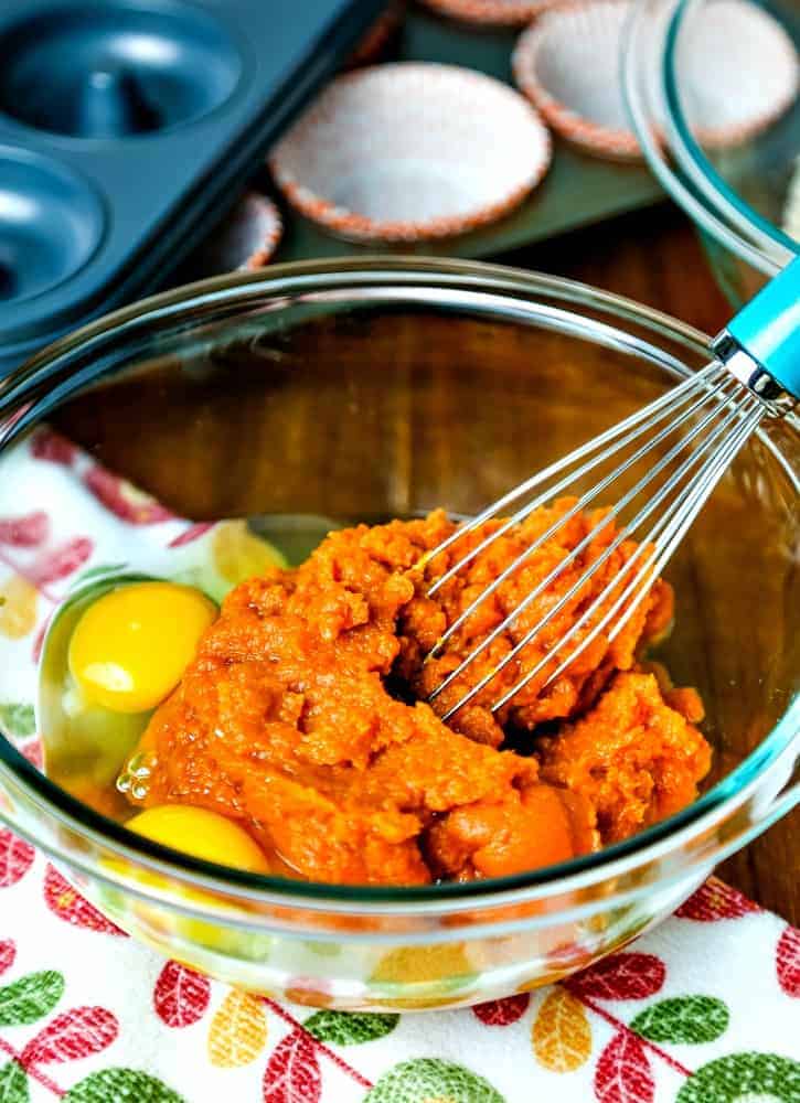 Whisking together canned pumpkin and eggs in a bowl with a whisk