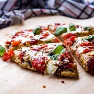 Mini caorese pizza cut into slices on a pizza board
