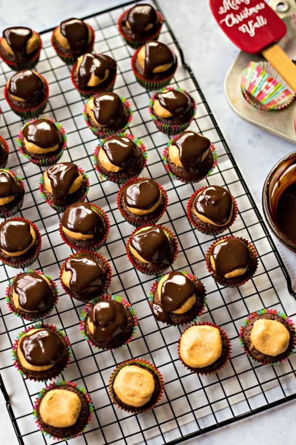 buckeye brownie bites on a wire rack with melted chocolate