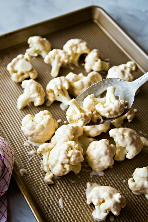 Coated cauliflower on baking sheet