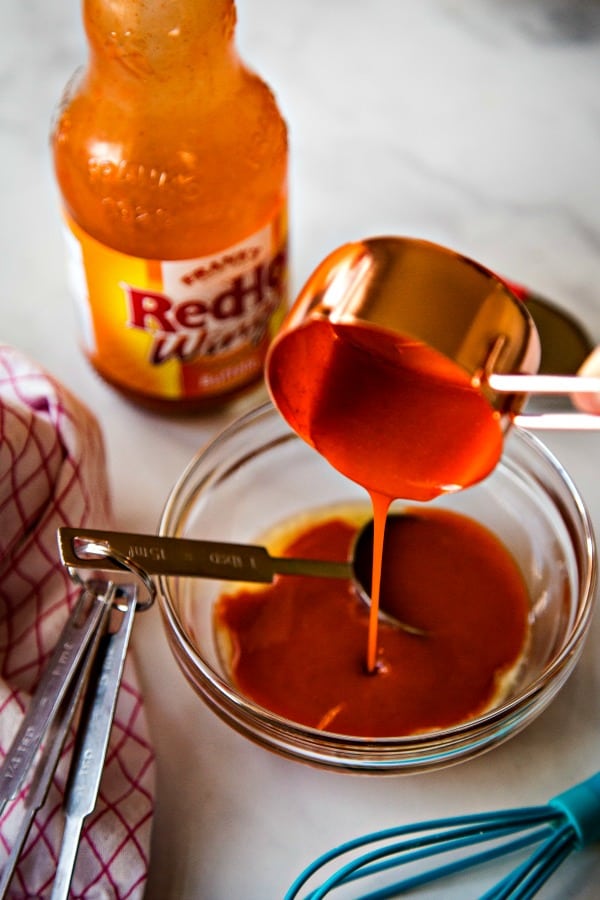 Adding buffalo wing sauce to melted butter