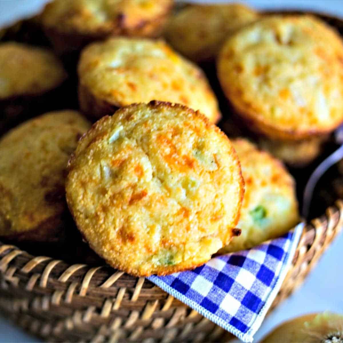 a basket lined with a purple gingham napkin with Mexican cornbread muffins