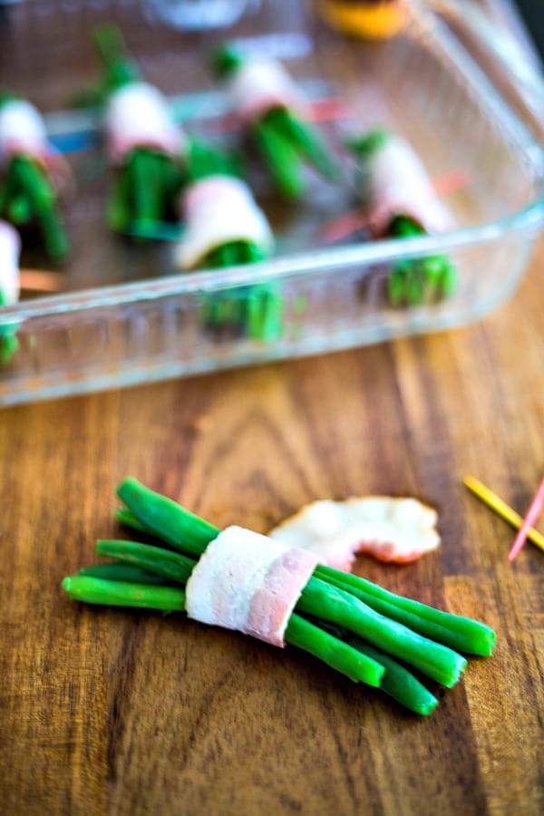 blanched green beans wrapped in bacon with a toothpick