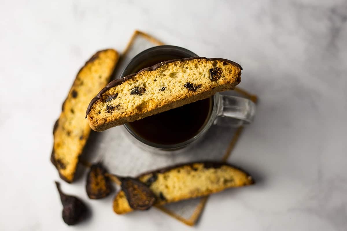 Fig and Walnut Biscotti with Dark Chocolate on top of coffee cup