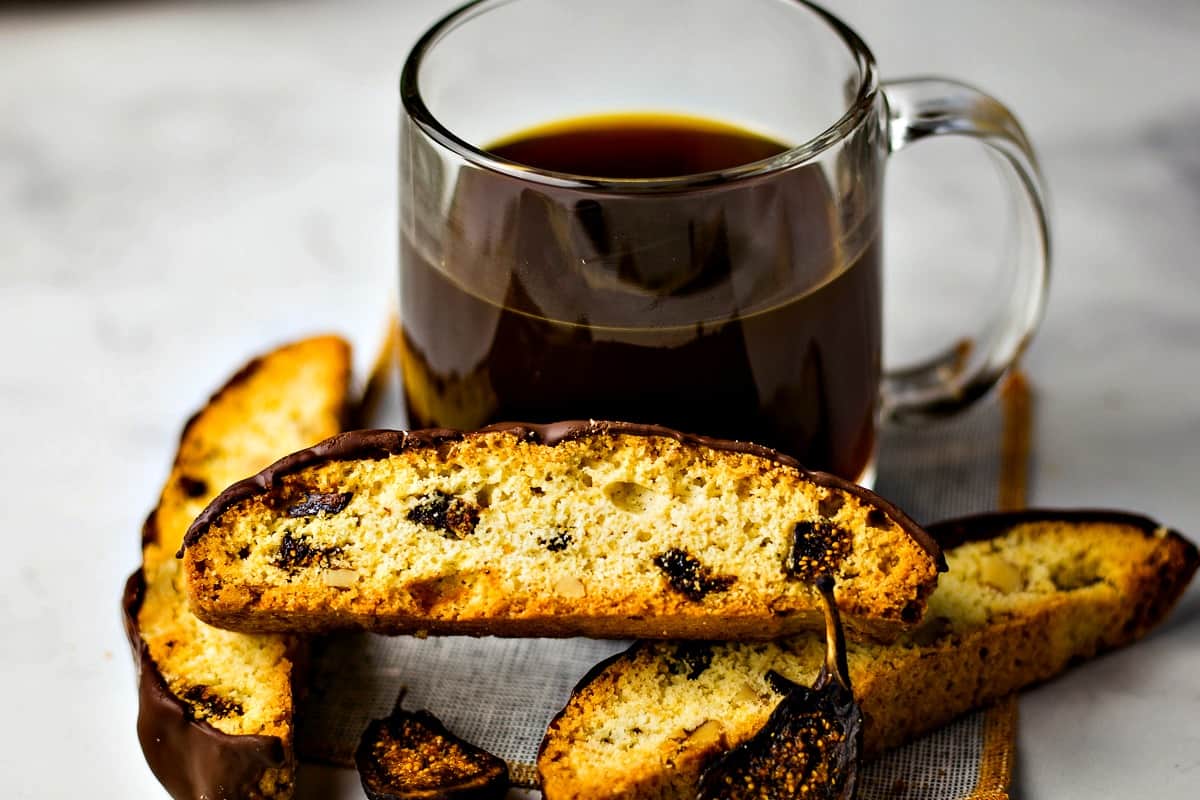 Fig and Walnut Biscotti with Dark Chocolate in front of coffee cup