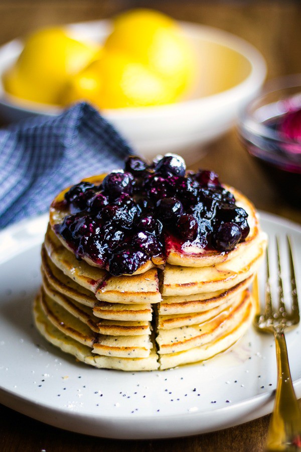 Stack of Lemon Poppy Seed Pancakes with blueberry compote on white plate