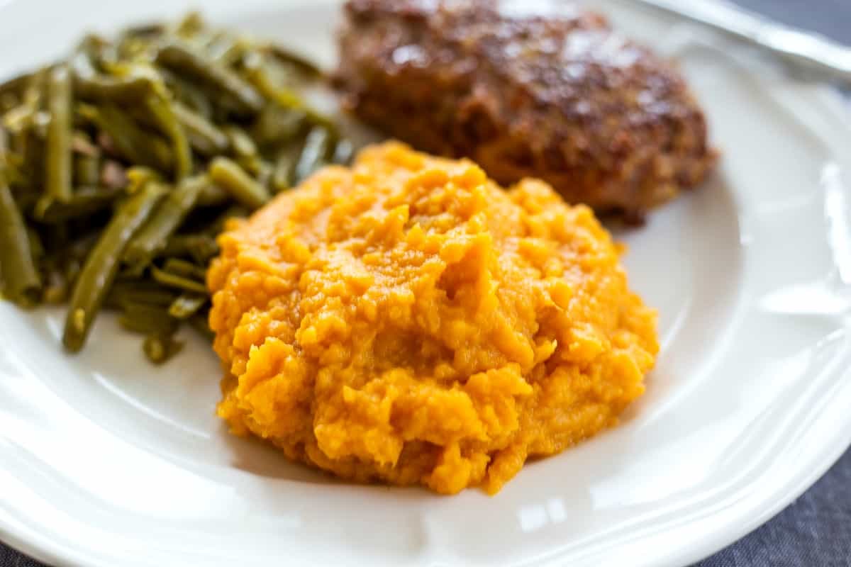 Mashed Sweet Potatoes on dinner plate with green beans and meatloaf