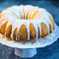 Lemon Bundt Cake with lemon glaze on a white cake stand