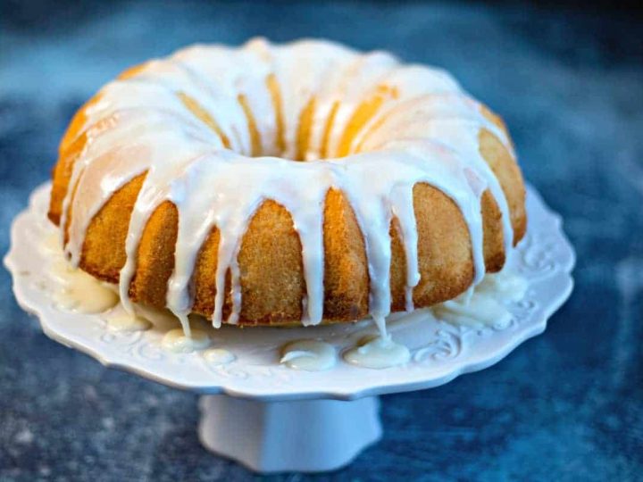 Lemon Bundt Cake with lemon glaze on a white cake stand