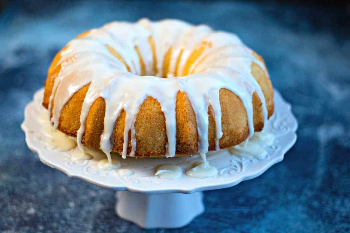 Lemon Bundt Cake with lemon glaze on a white cake stand