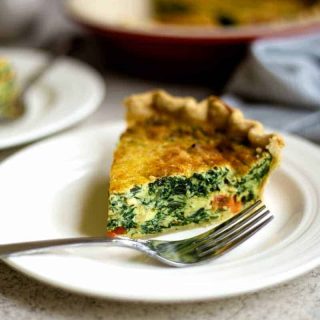 slice of spinach quiche on a white plate