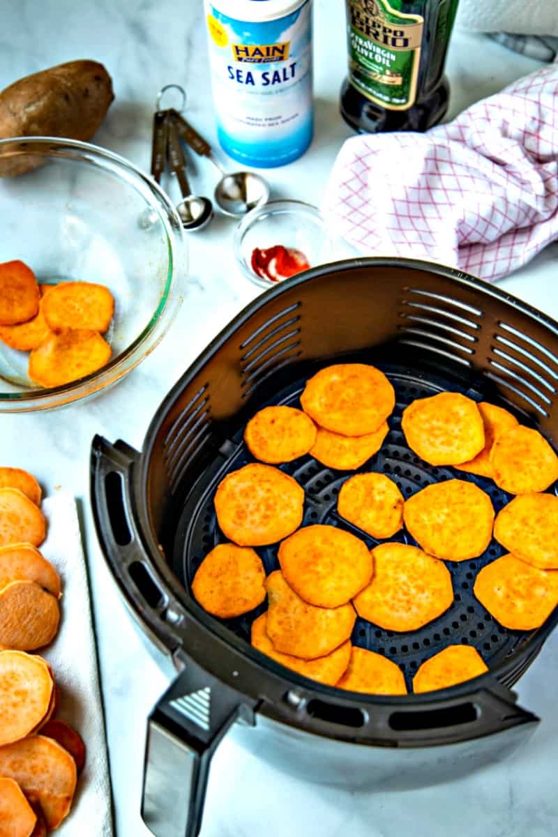 raw sweet potato sliced in air fryer basket