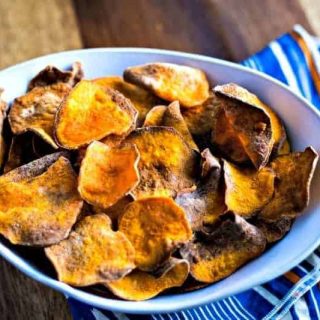sweet potato chips in a white bowl with a blue and orange napkin