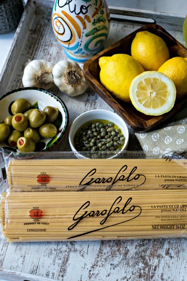 tray with recipe ingredients including pasta, capers, and lemons