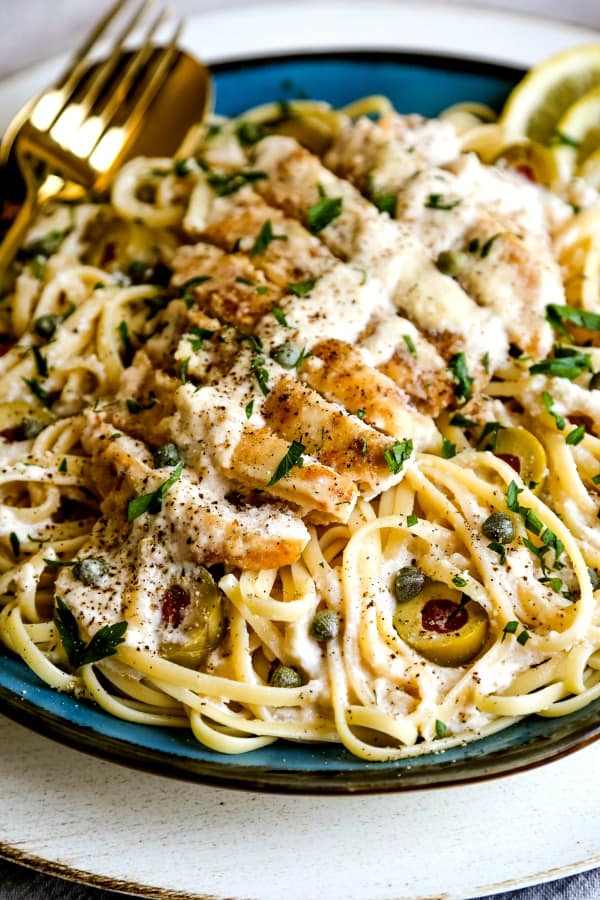 lemon chicken on top of a plate of pasta