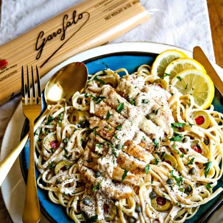 linguini with chicken in a lemon parmesan sauce on a blue plate