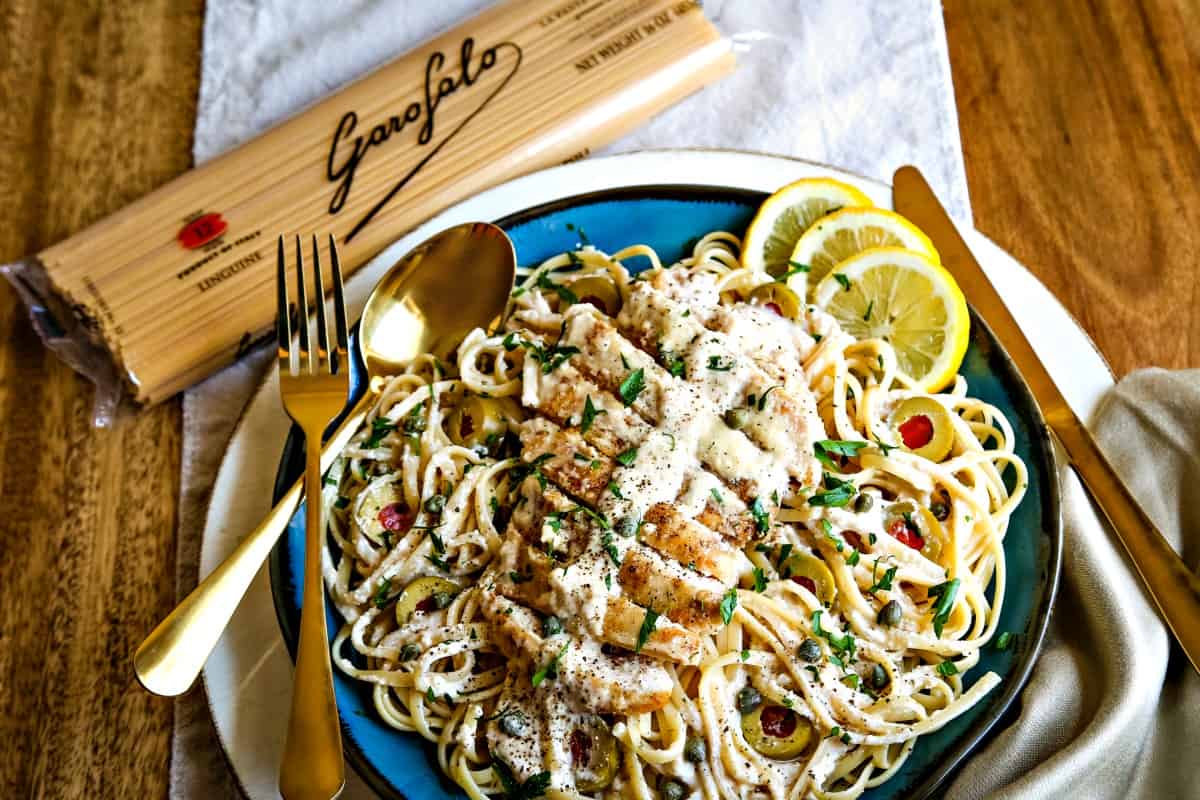 place setting with pasta dish on a wooden table