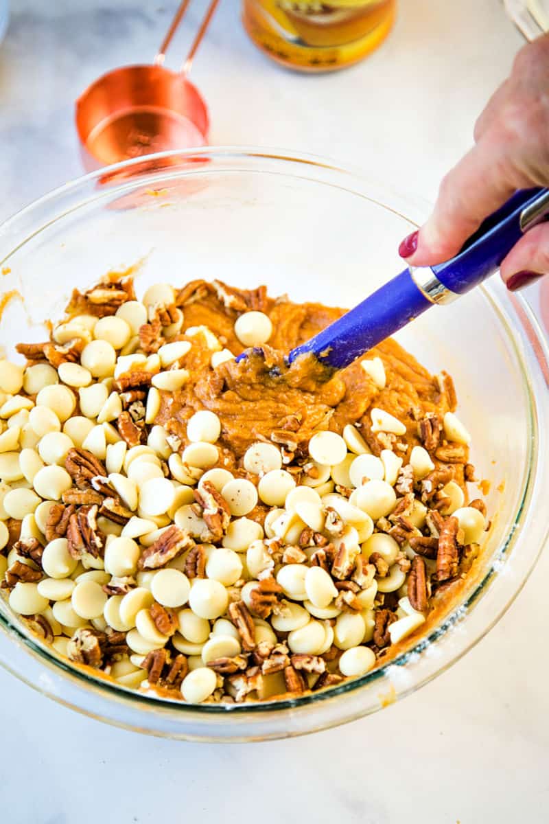 mixing batter for pumpkin bars in a glass bowl