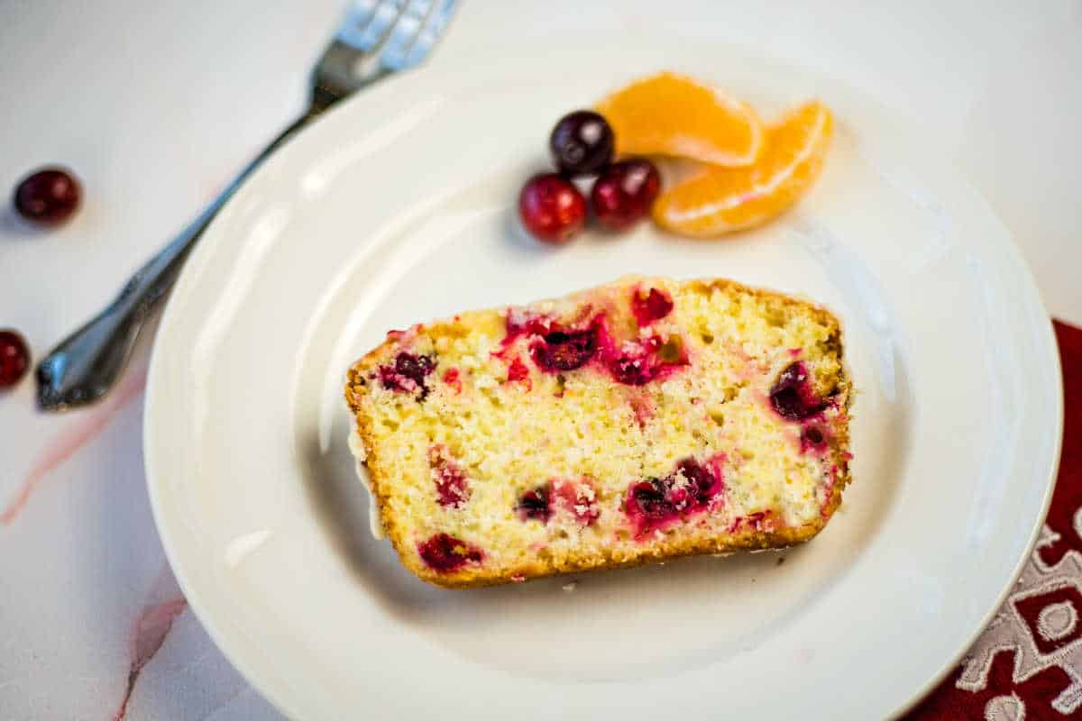 a slice of cranberry orange bread on a white plate