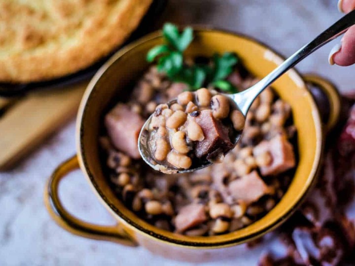 a spoonful of black eyed peas coming out of a bowl
