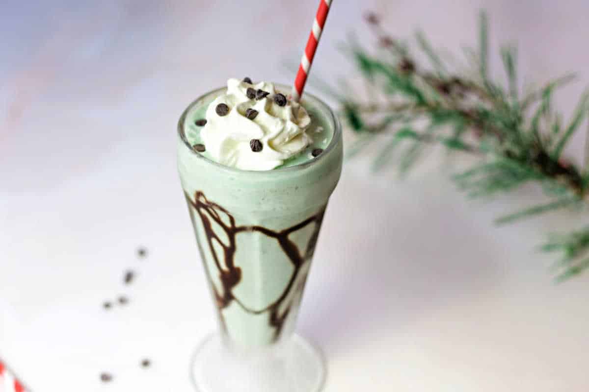 mint chocolate chip milkshake with a candy cane striped straw