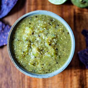 A bowl of food on a table, with Roasted Tomatillo Salsa