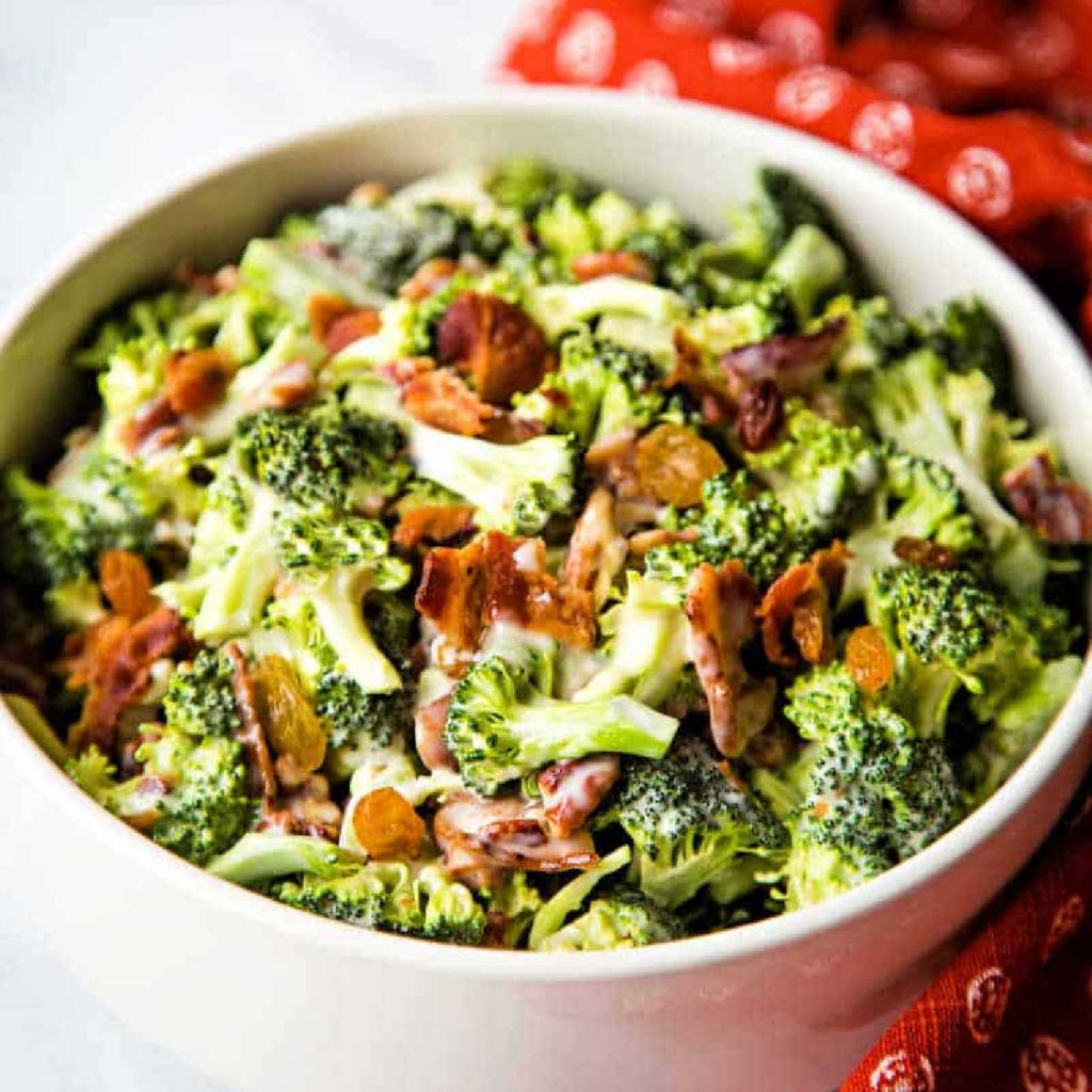 broccoli and bacon salad in a white bowl.