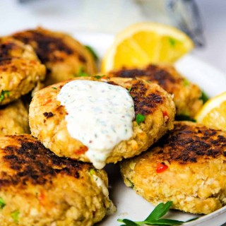 A plate of salmon patties with lemon slices