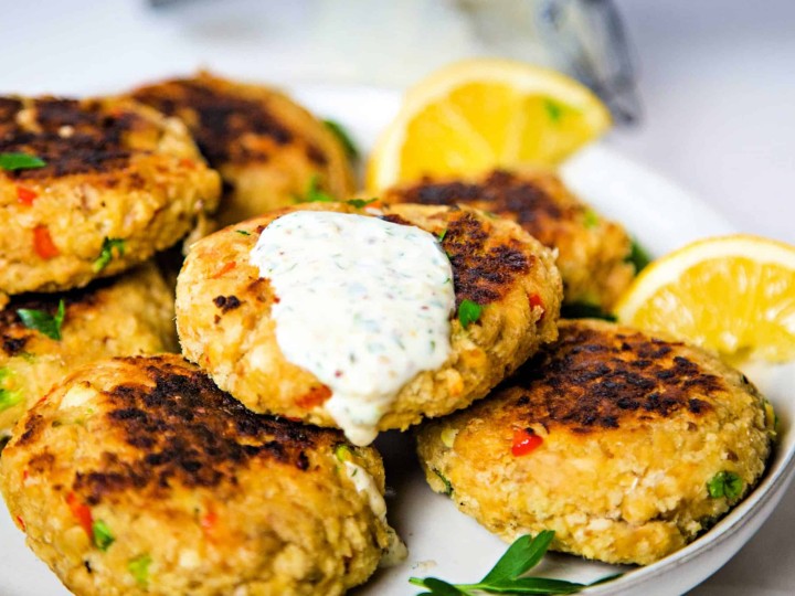 A plate of salmon patties with lemon slices