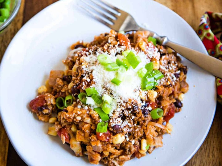 beef enchilada skillet topped with cojita cheese and green onions