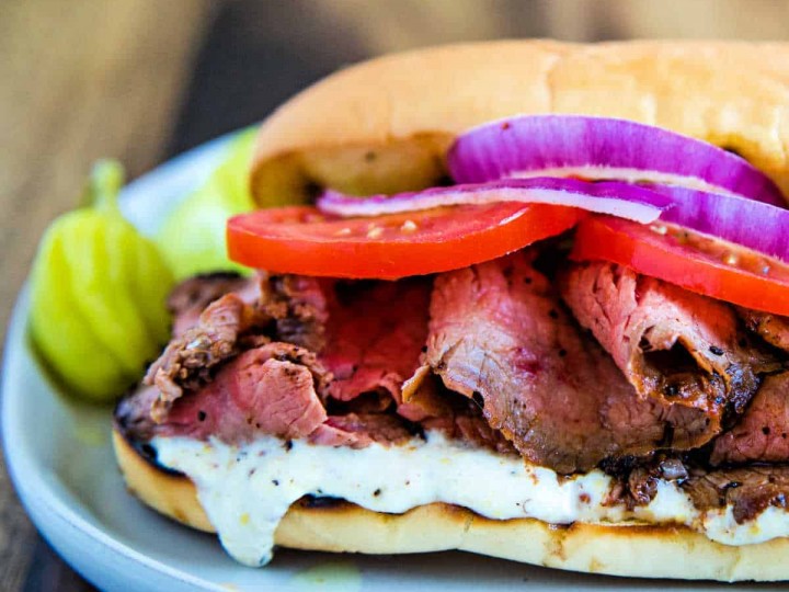 A sandwich on a plate, with Grilled Steak Sandwich