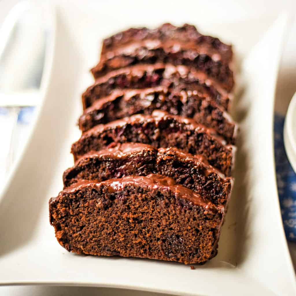 chocolate cherry loaf cake sliced and on a platter