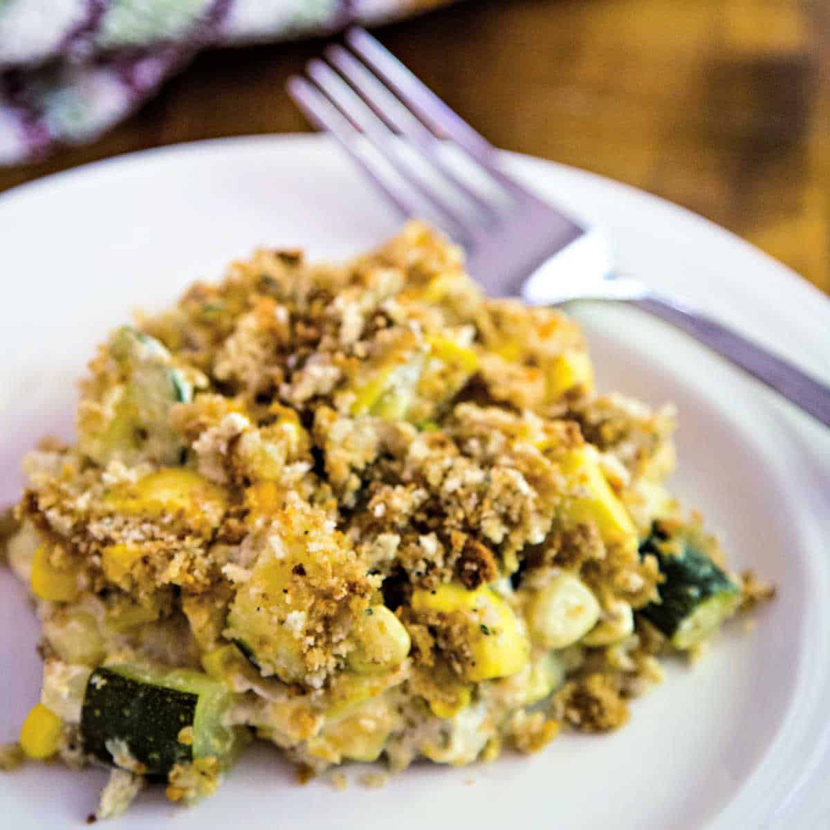 a serving of squash and zucchini casserole on a white plate
