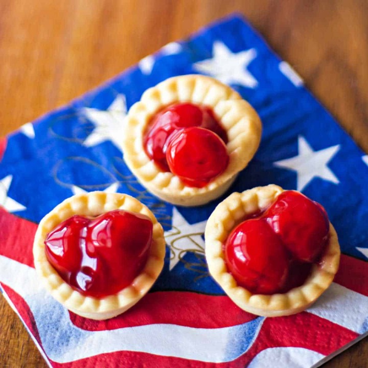 3 bite size cherry tarts on a patriotic napkin