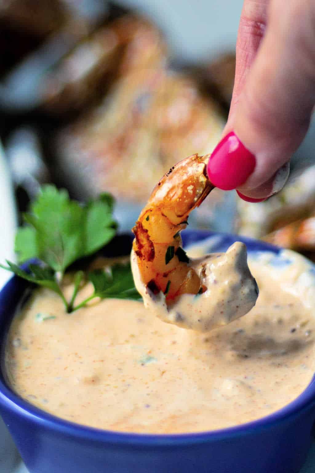 dipping shrimp in remoulade sauce