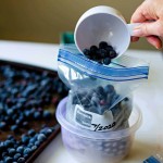 pouring blueberries into a freezer bag