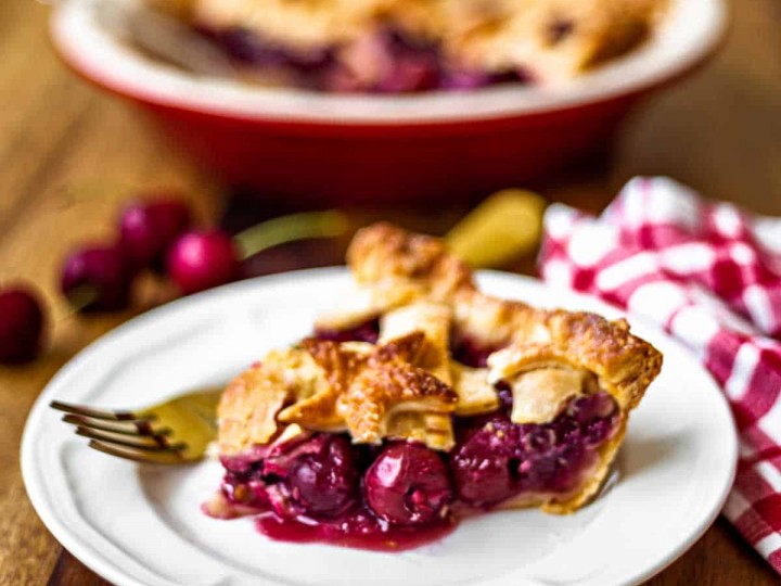 a slice of 5-star cherry pie on a white plate with a gold fork