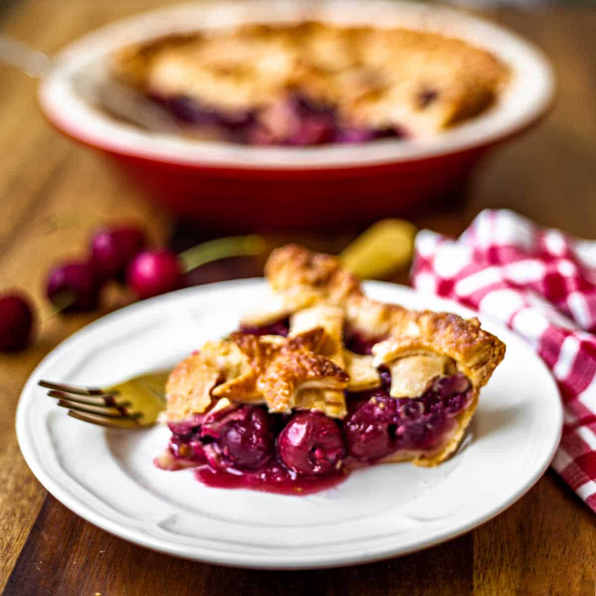 a slice of 5-star cherry pie on a white plate with a gold fork