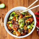 Sriracha Chicken and Brussels Sprouts Stir Fry in a white bowl with chopsticks